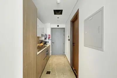 a hallway leading to a kitchen with a hallway leading to a door at Luxury Retreat in Arjan with Refined Living in Dubai