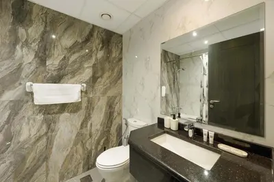 a bathroom with a sink and a toilet and a mirror at Elite Studio Retreat in Business Bay District in Dubai