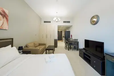a bedroom with a bed and a living room at Elite Studio Retreat in Business Bay District in Dubai