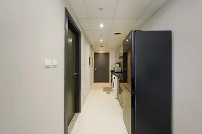 a hallway with a black door leading to a kitchen at Elite Studio Retreat in Business Bay District in Dubai