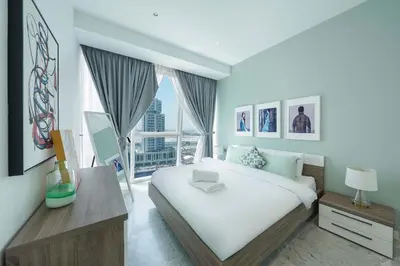 a bedroom with a white bed and a large window at Designer 1BR Retreat With Stunning Canal View in Dubai