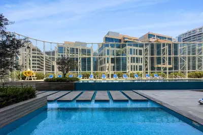 a swimming pool in front of a large building at Designer 1BR Retreat With Stunning Canal View in Dubai
