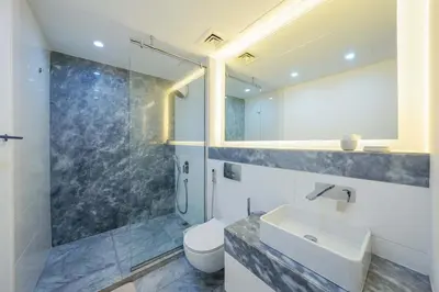 a bathroom with a sink and a toilet and a shower at Designer 1BR Retreat With Stunning Canal View in Dubai