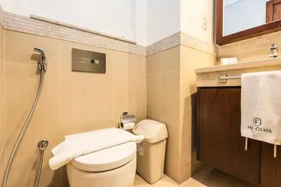 a small bathroom with a toilet and a shower at FIRST CLASS 2BR Sky Views City Vibes in Dubai