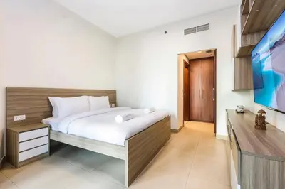 a bedroom with a bed and a flat screen tv at FIRST CLASS 2BR Sky Views City Vibes in Dubai