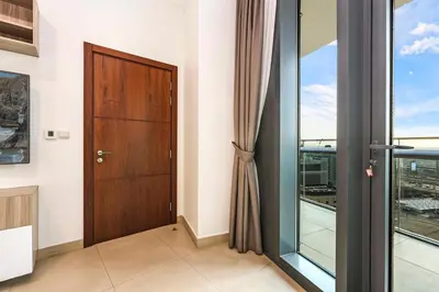 a wooden door in a room with a window at FIRST CLASS 2BR Sky Views City Vibes in Dubai
