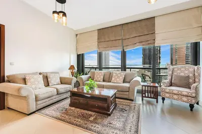 a living room with two couches and a table at FIRST CLASS 2BR Sky Views City Vibes in Dubai