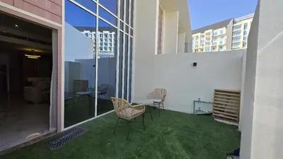 a balcony with chairs and a table on a building at Stylish 1BR Loft TH in Rukan in Dubai
