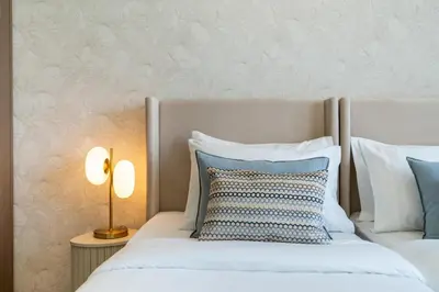 a bedroom with two white beds and a lamp at Grande, Luxurious 2 BR, Burj Khalifa & Fountain view in Dubai