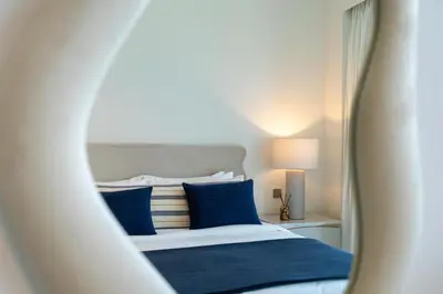 a bedroom with a bed with blue pillows and a mirror at Grande, Luxurious 2 BR, Burj Khalifa & Fountain view in Dubai
