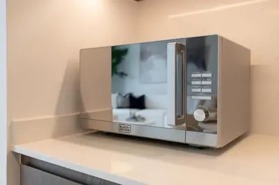 a microwave oven on a shelf in a room at Grande, Luxurious 2 BR, Burj Khalifa & Fountain view in Dubai