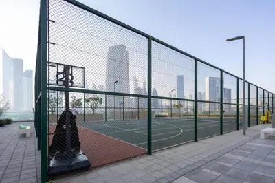a tennis court with a fence and a tennis court at Maison Privee - Urban & Elegant Stay Just Steps from Burj Khalifa in Dubai