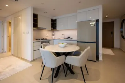 a kitchen with a table and chairs in a kitchen at Maison Privee - Urban & Elegant Stay Just Steps from Burj Khalifa in Dubai