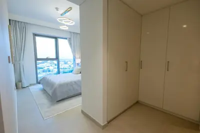 a bedroom with a bed and a large window at Maison Privee - Urban & Elegant Stay Just Steps from Burj Khalifa in Dubai
