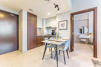 a kitchen and dining room with a table and chairs at High-Rise 2BR with Dubai Water Canal View, Quick Access to Downtown, Vera Tower, Business Bay by Deluxe Holiday Homes in Dubai