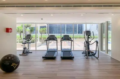 a gym with treadmills and ellipticals in a building at High-Rise 2BR with Dubai Water Canal View, Quick Access to Downtown, Vera Tower, Business Bay by Deluxe Holiday Homes in Dubai