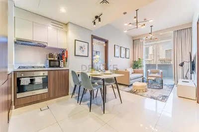 a kitchen and living room with a table and chairs at High-Rise 2BR with Dubai Water Canal View, Quick Access to Downtown, Vera Tower, Business Bay by Deluxe Holiday Homes in Dubai