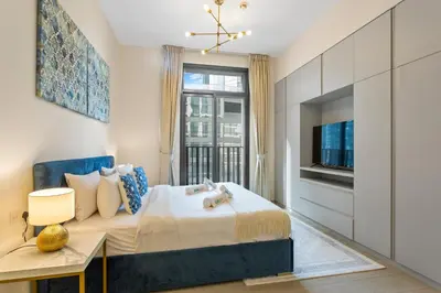 a bedroom with a bed with a tv and a window at Art-Inspired 1 Bedroom in Wilton Terraces in Dubai