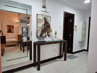 a living room with a table with a picture on the wall at Stunning 1Bedroom Apartment 5 min walking distance Metro and JBR Beach in Dubai