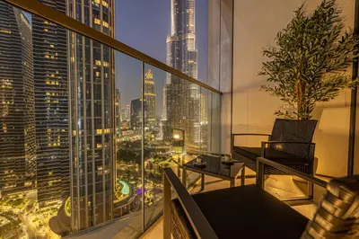 a balcony with a view of a city at night at Exclusive Burj Khalifa View, Steps From Dubai Mall, Infinity Pool in Dubai