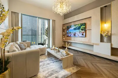 a living room with a couch and a tv at Exclusive Burj Khalifa View, Steps From Dubai Mall, Infinity Pool in Dubai