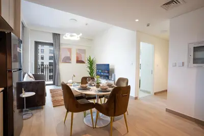 a kitchen and dining room with a table and chairs at Elegant at Creek Beach Lotus 1BHK in Dubai