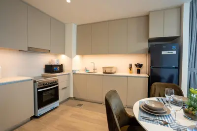a small kitchen with a table and a refrigerator at Elegant at Creek Beach Lotus 1BHK in Dubai