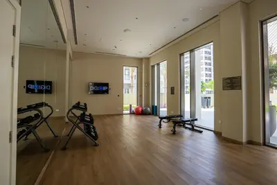 a gym with two treadmills and a hard wood floor at Elegant at Creek Beach Lotus 1BHK in Dubai