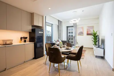 a kitchen and dining room with a table and chairs at Elegant at Creek Beach Lotus 1BHK in Dubai