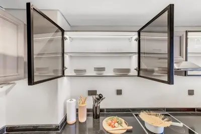 a kitchen with glass cabinets and a plate of food on a counter at Stylish 1BR in Marina - 5 Min Walk to Beach in Dubai