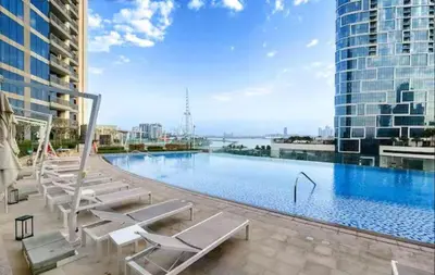 a large swimming pool with lounge chairs on a building at Vogue Marina 52-42 Towers near Ain Dubai and JBR Beach, Two Bedroom Apartment with Balcony Canal and Skyline views, Access to all Amenities in Dubai