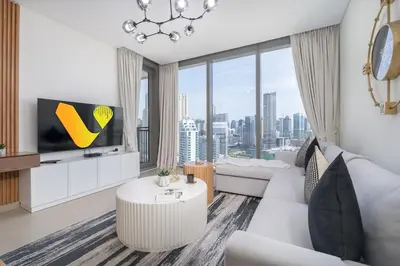 a living room with white furniture and a large window at Vogue Marina 52-42 Towers near Ain Dubai and JBR Beach, Two Bedroom Apartment with Balcony Canal and Skyline views, Access to all Amenities in Dubai