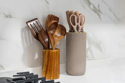 two vases filled with wooden utensils on a wall at Luxurious JVC Studio Near Circle Mall & Parks in Dubai