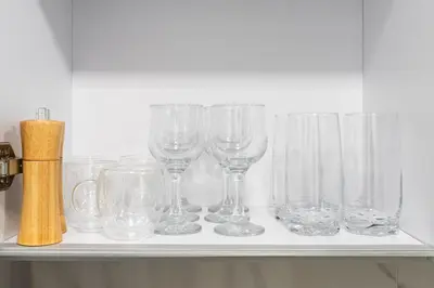a row of glasses sitting on a shelf at Luxurious JVC Studio Near Circle Mall & Parks in Dubai