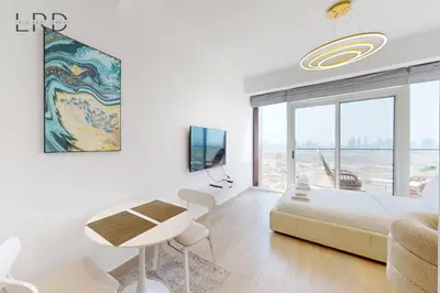 a white room with a bed and a table and chairs at Chic and Aesthetic Studio! Move-In Ready in Dubai