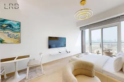 a white bedroom with a large bed and a couch at Chic and Aesthetic Studio! Move-In Ready in Dubai