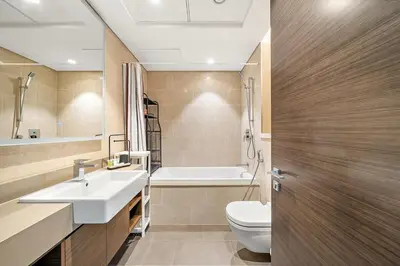 a bathroom with a sink and a toilet and a tub at Luxurious 2BR Apartment in Sobha Hartland Greens in Dubai