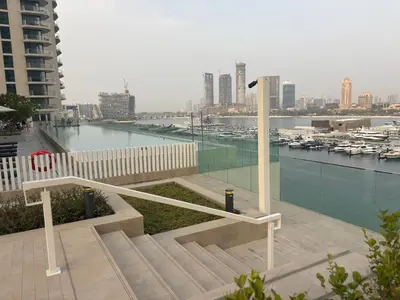 a bench with a view of a harbor and a city at Best Emaar Beachfront view one bedroom in Dubai