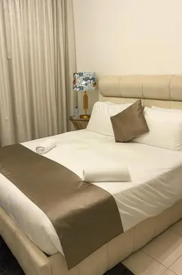 a large bed with white and brown sheets and pillows at Best Emaar Beachfront view one bedroom in Dubai