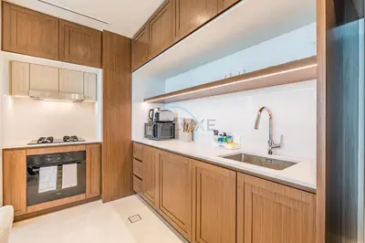 a kitchen with wooden cabinets and a sink at 1BR With Private Beach Access, Near Dubai Marina Walk, Next to Dubai Harbour Marina & Yacht Club, Palace Beach Residence, Dubai Marina by Deluxe Holiday Homes in Dubai