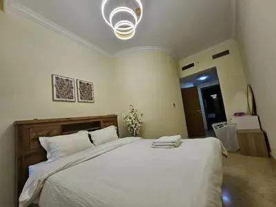 a bedroom with a large white bed with a light at The Dorra Bay Offers Stunning 2bedroom Duplex JBR Sea View Marina Canal view in Dubai