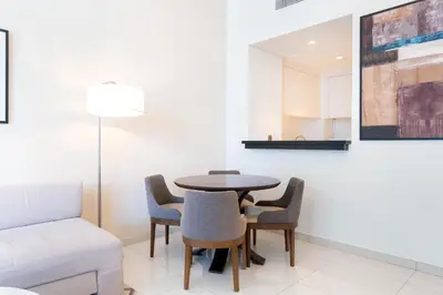 a dining room with a table and chairs and a couch at Ahlan HH - Stylish Suite Heart of Business Bay Avanti Tower in Dubai