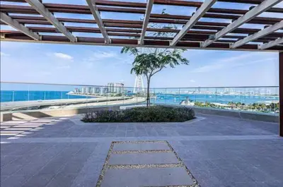 a patio with a palm tree and a view of the ocean at Vogue Marina 52-42 Towers near Ain Dubai and JBR Beach, Two Bedroom Apartment with Balcony Canal and Skyline views, Access to all Amenities in Dubai