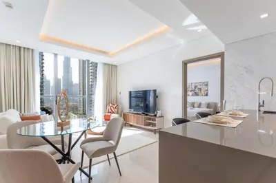 a living room with a dining table and a living room at Luxury Burj & Fountain View Retreat in Dubai