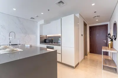 a kitchen with white cabinets and a counter at Luxury Burj & Fountain View Retreat in Dubai