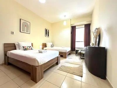 a bedroom with a bed and a tv and a couch at Centrally Located Close to Beach in Dubai