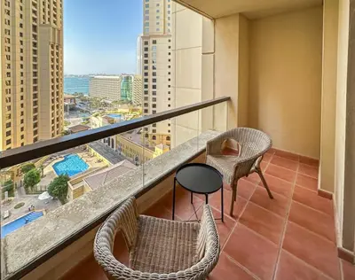 a balcony with chairs and a table and a view of a city at Centrally Located Close to Beach in Dubai