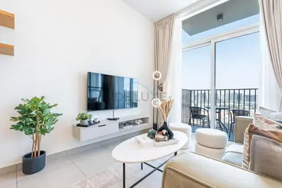 a living room with a couch and a tv at Located Minutes walk to Dubai Hills Park, Near Dubai Hills Mall , Socio Tower 1, Dubai Hills by Deluxe Holiday Homes in Dubai