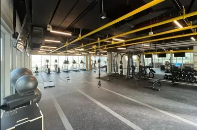 a gym with a lot of people exercising in it at Located Minutes walk to Dubai Hills Park, Near Dubai Hills Mall , Socio Tower 1, Dubai Hills by Deluxe Holiday Homes in Dubai