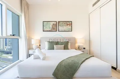 a white bedroom with a large bed and a window at Located Minutes walk to Dubai Hills Park, Near Dubai Hills Mall , Socio Tower 1, Dubai Hills by Deluxe Holiday Homes in Dubai